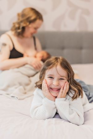 A series of candid lifestyle photos showing joyful moments on a light gray bed with white bedding.