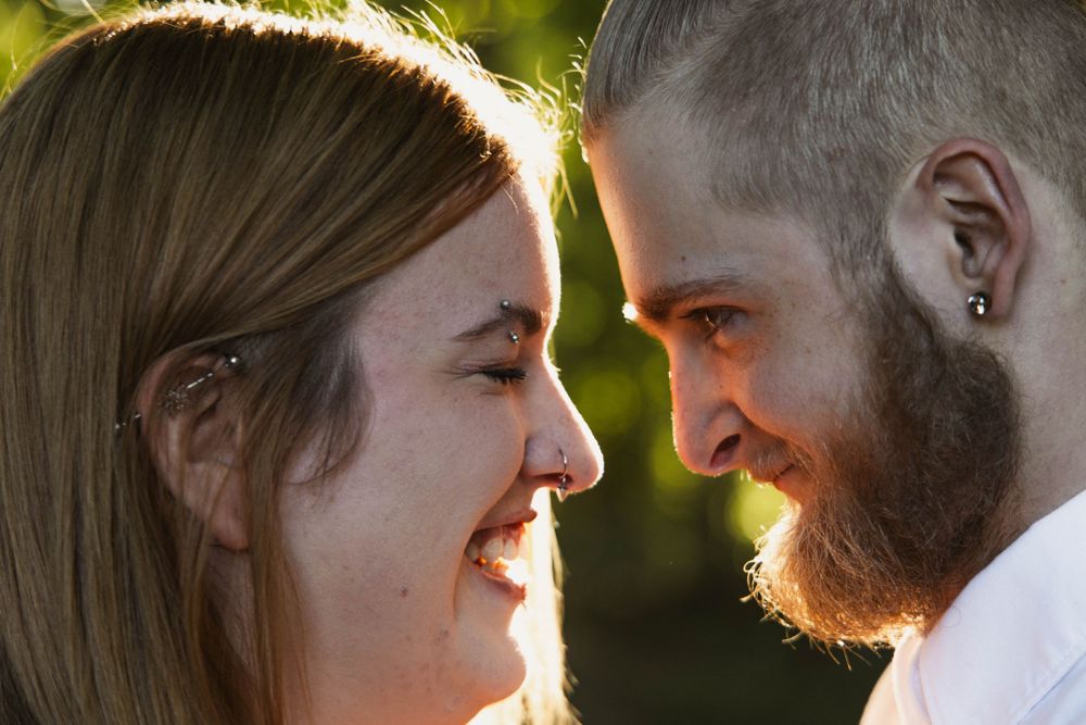A romantic couple sharing an intimate moment outdoors in golden sunlight.