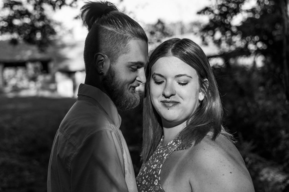 A black and white portrait of a couple sharing a tender moment together.