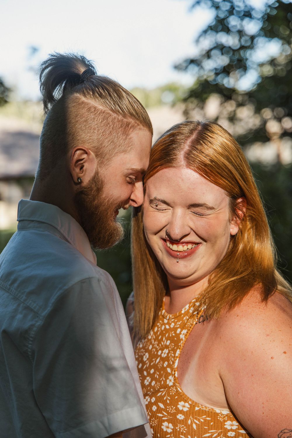 A joyful couple sharing a close intimate moment in warm sunlight.