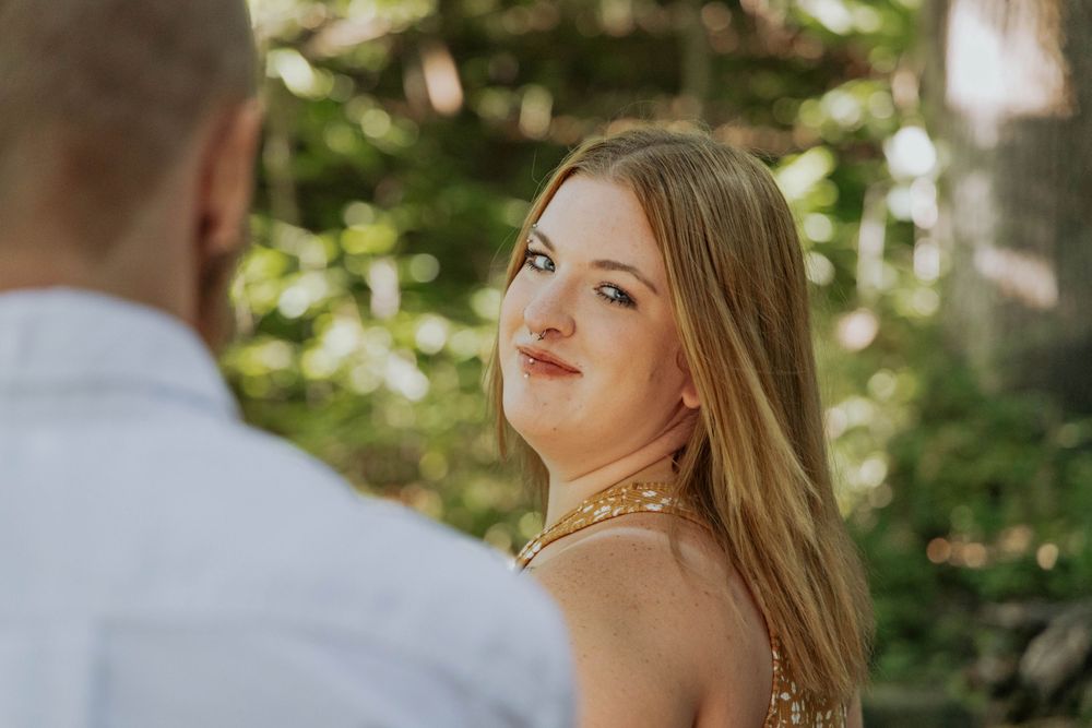 A romantic outdoor portrait with soft natural lighting through trees.