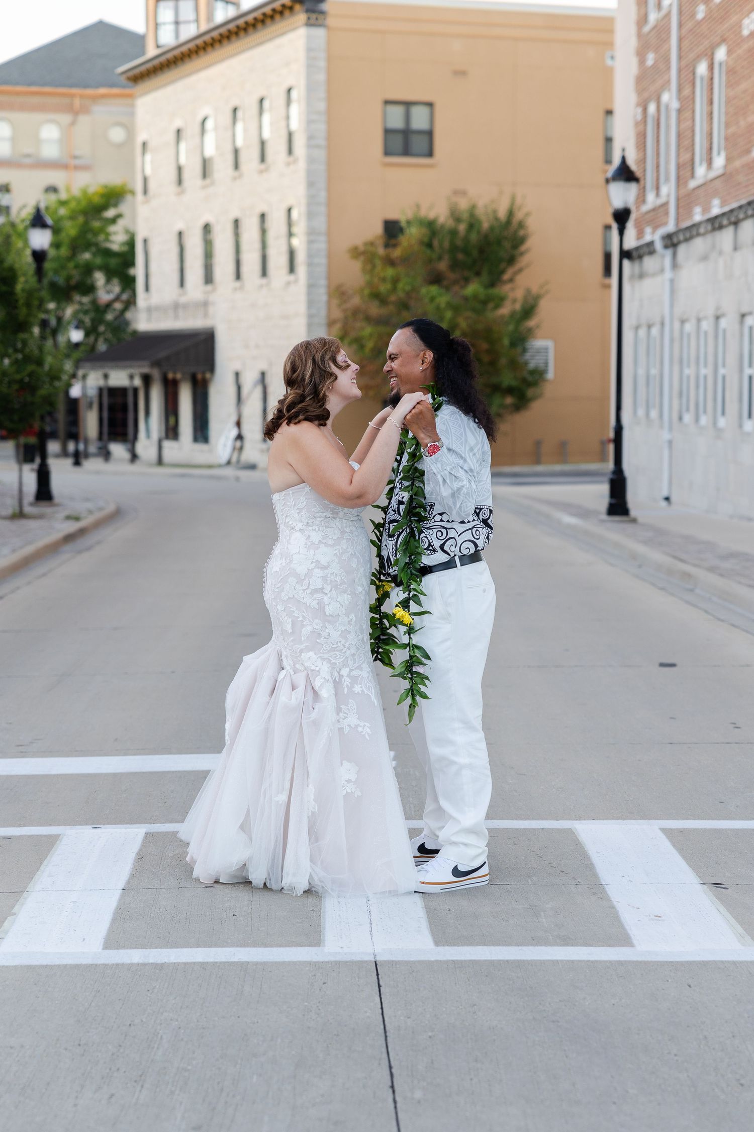 Bride and groom kissing in sidewalk on a city street with an urban feel.