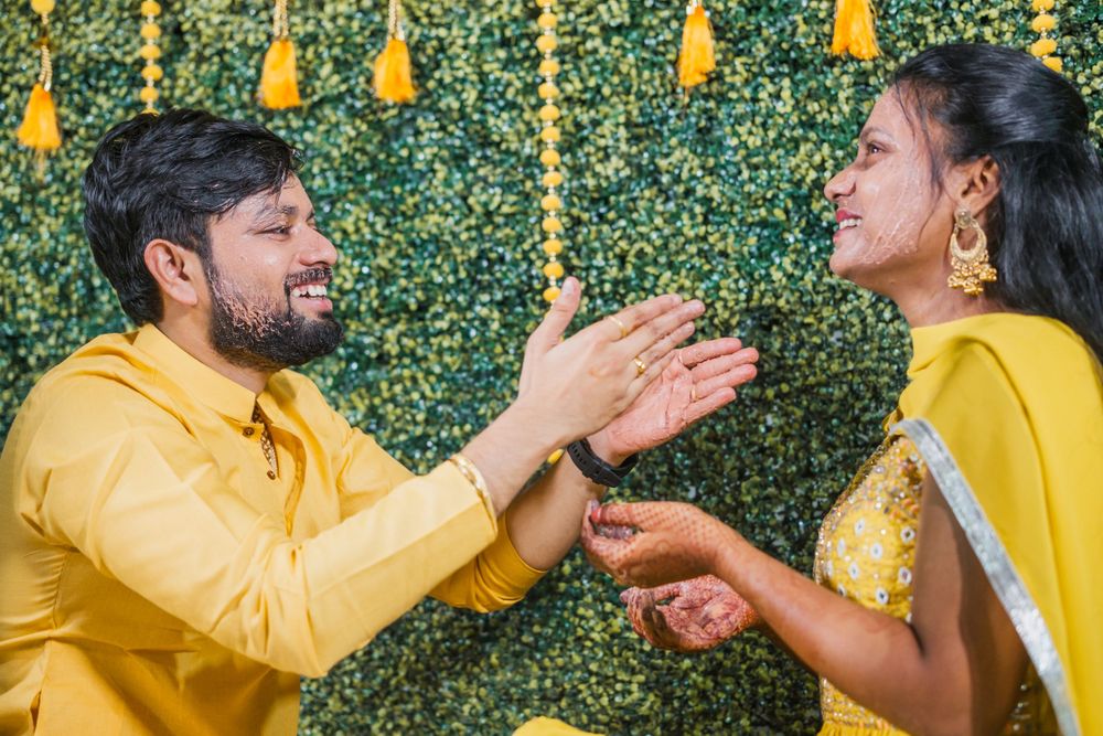 Festive celebration with yellow decor and traditional attire against green backdrop.