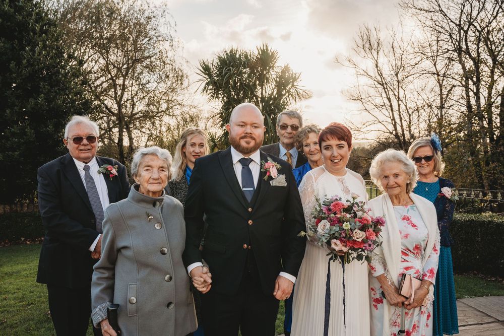 Wedding party poses together outdoors during sunset celebration.