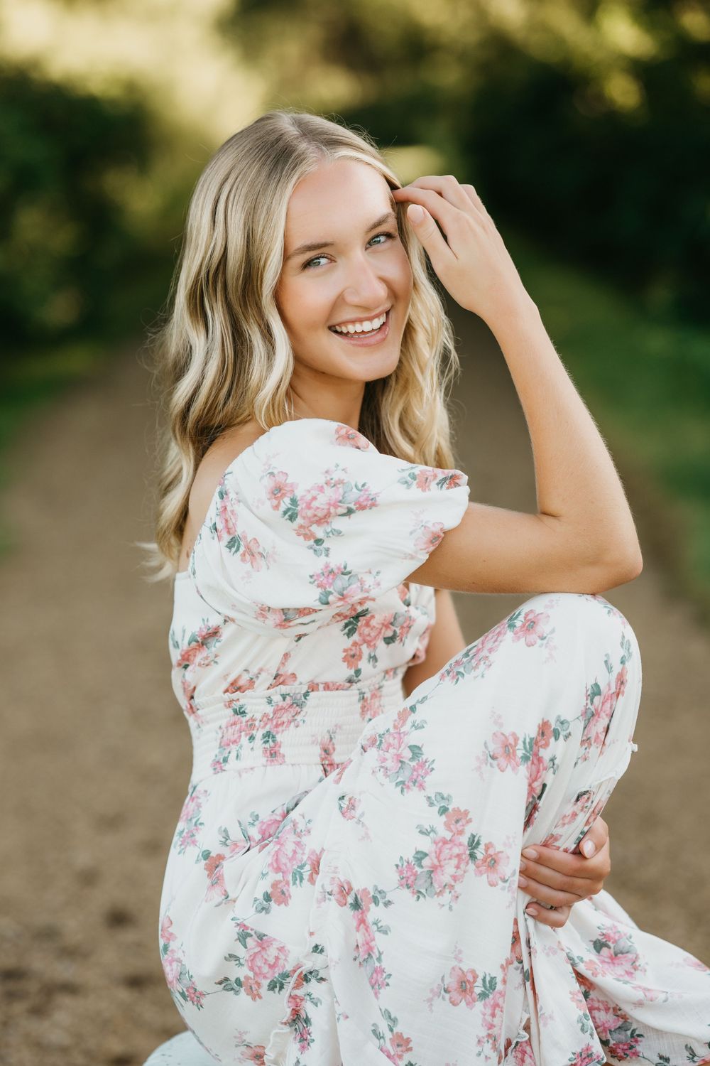 A series of outdoor portrait photos featuring someone in a flowing white floral dress posing against a natural background.
