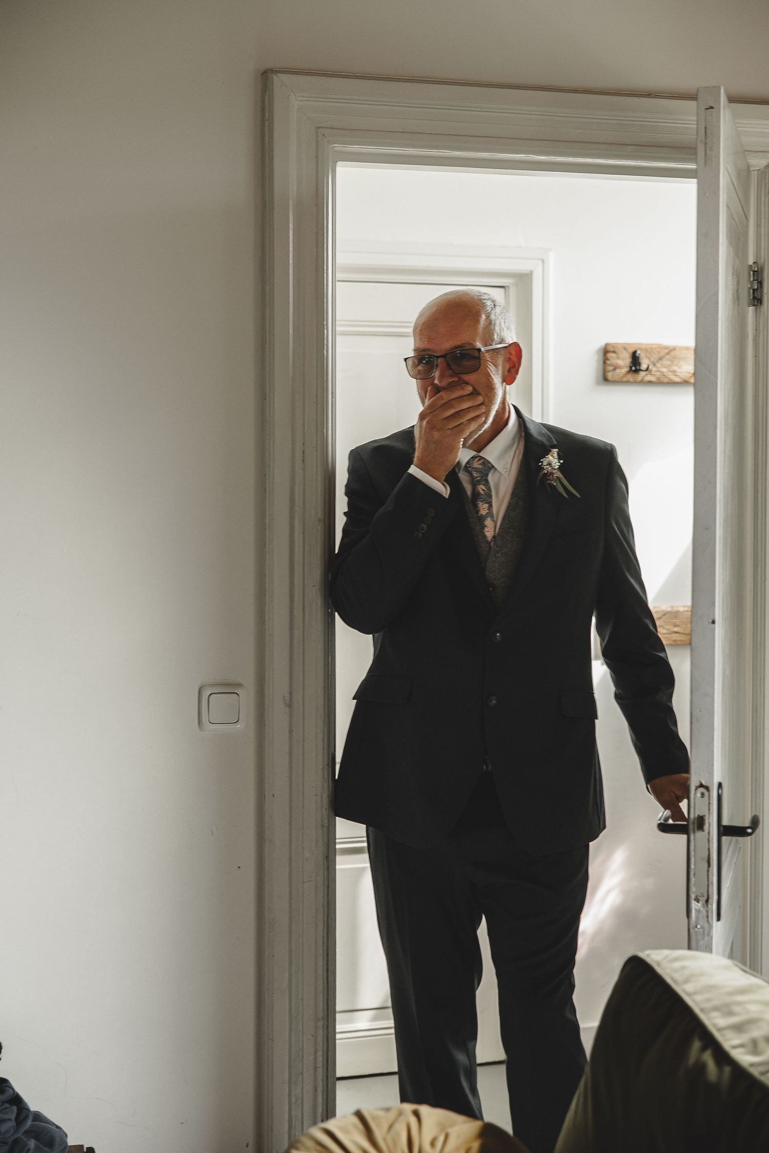 Series of candid shots showing men in black suits preparing in a bright white room.