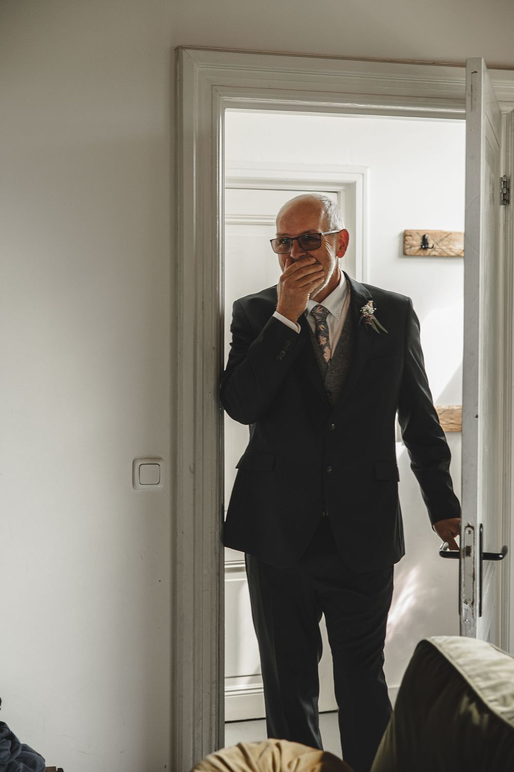 Series of candid shots showing men in black suits preparing in a bright white room.