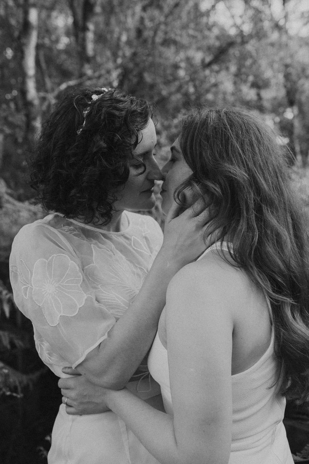A romantic black and white photo series showing a tender embrace between a couple in a wooded setting.