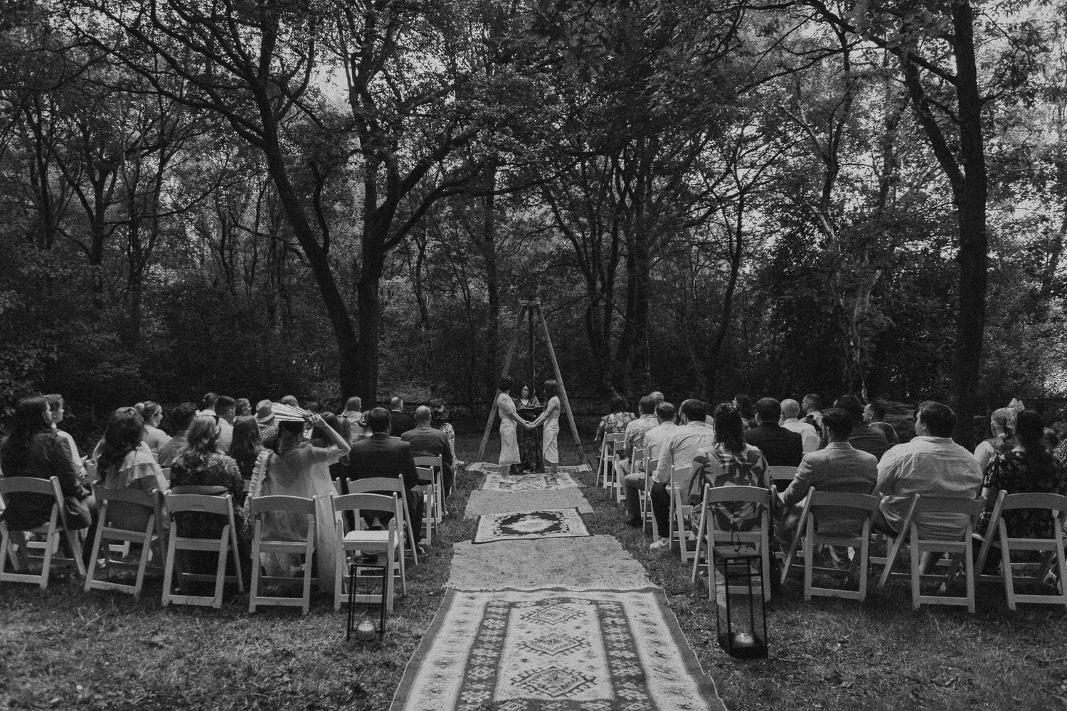A series of black and white wedding ceremony photos showing outdoor seating arrangements in a wooded setting.