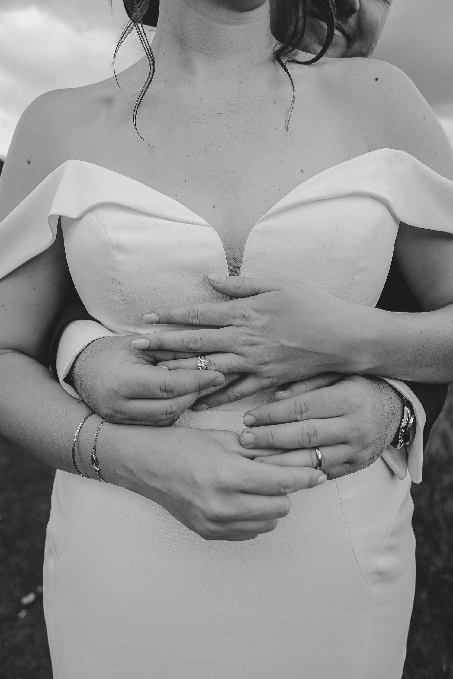 Black and white photo series showing hands cradling a pregnant belly in different gentle poses.