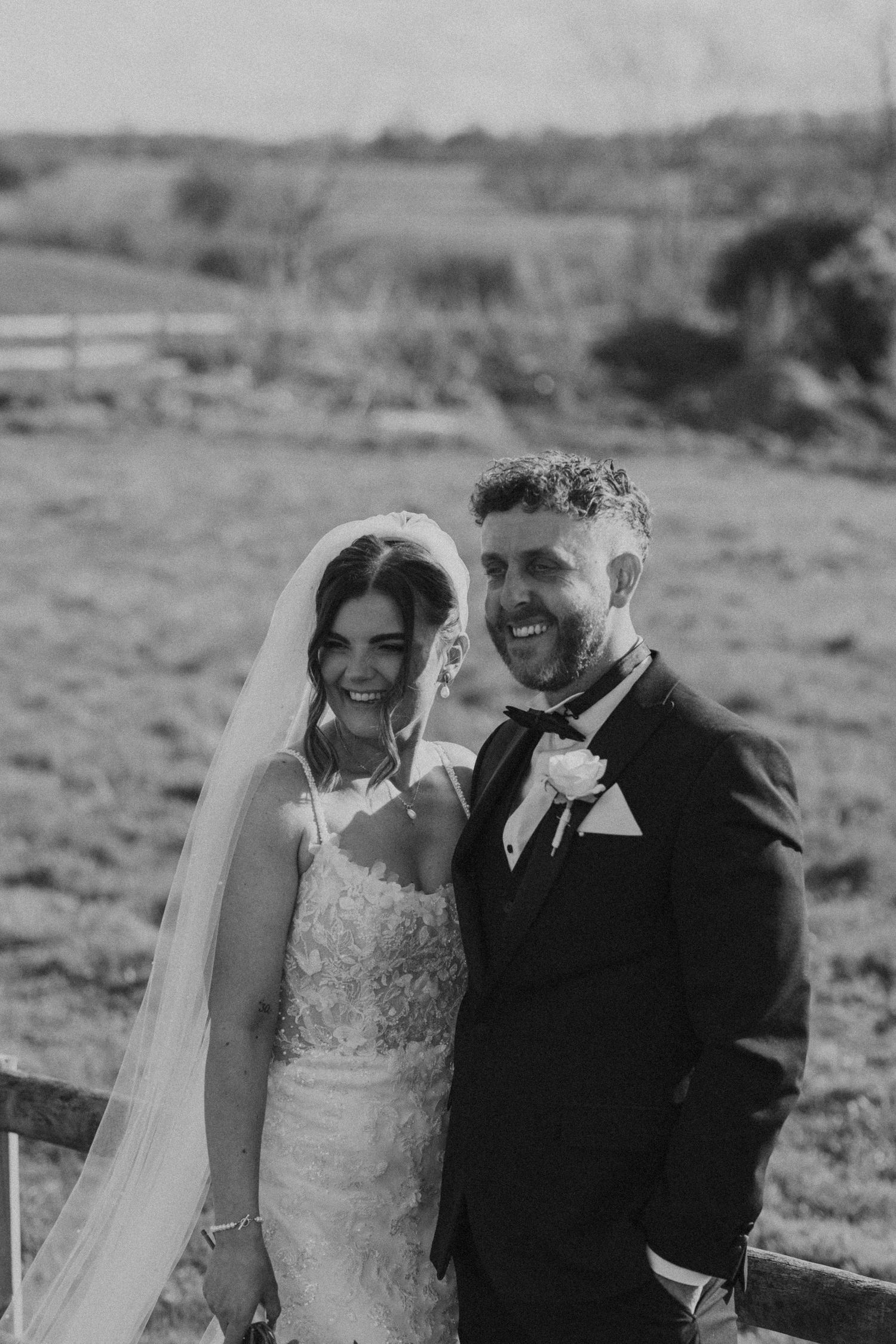 Black and white wedding photos showing joyful moments between a couple in a rustic outdoor setting.