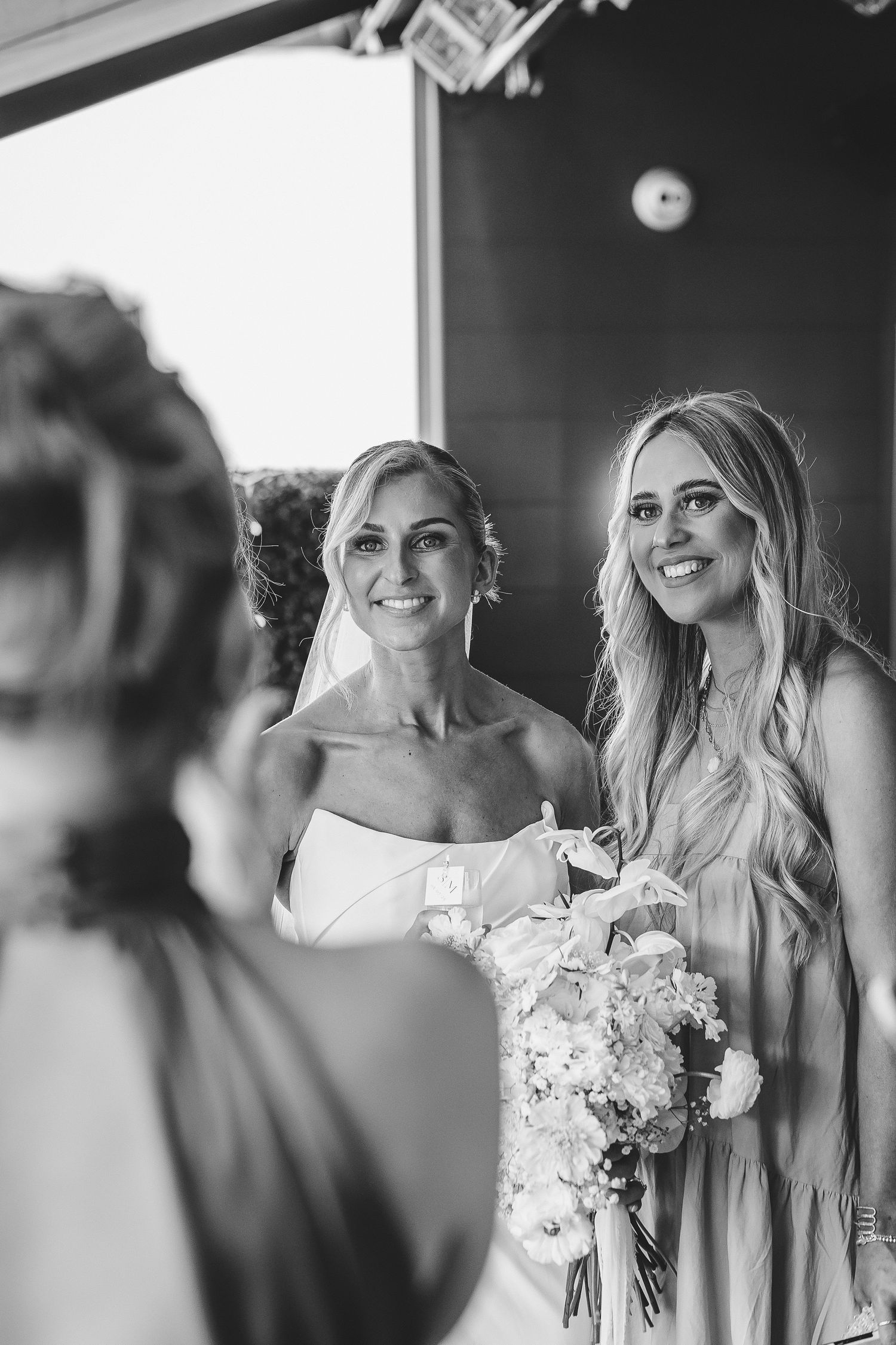 Black and white candid photos show bridesmaids sharing joyful moments while getting ready for a wedding celebration.