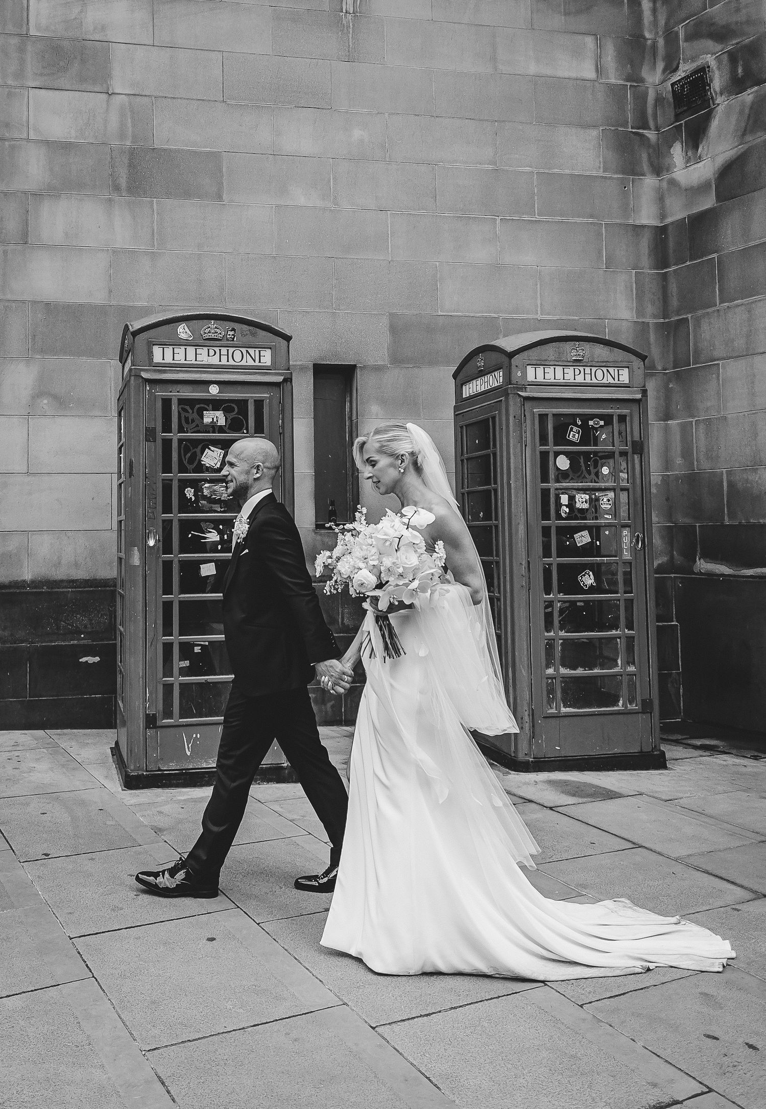 A sequence of black and white photos showing a wedding couple playfully peeking around a stone corner in a vintage style.