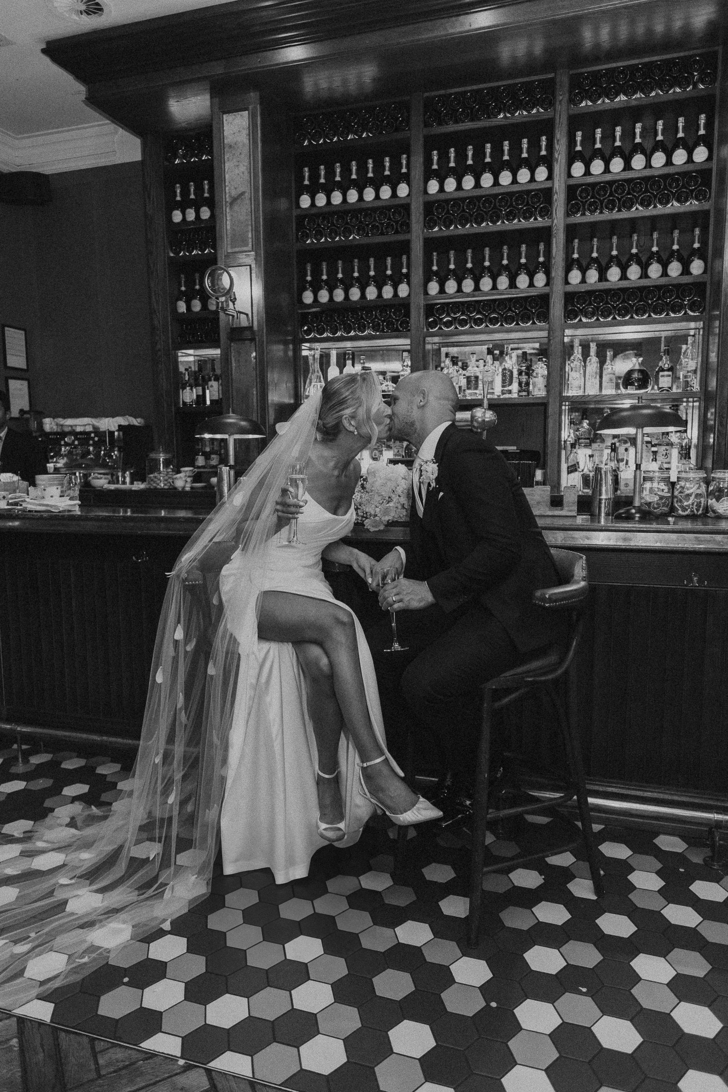 A sequence of black and white photos showing people seated at a vintage bar with a hexagonal tiled floor.