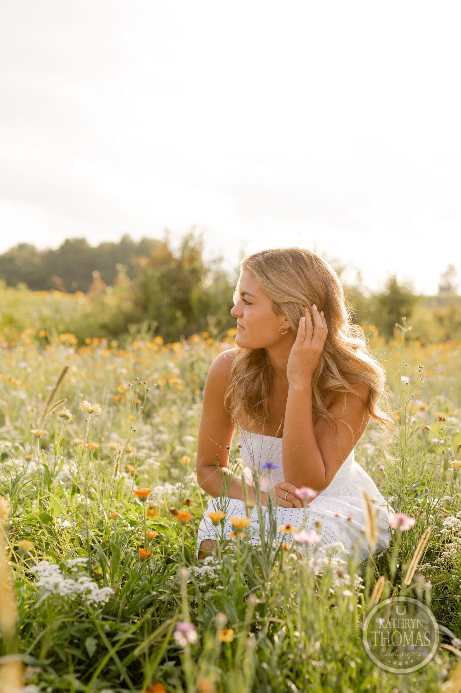 A romantic portrait in a wildflower field with someone wearing a white dress at golden hour.
