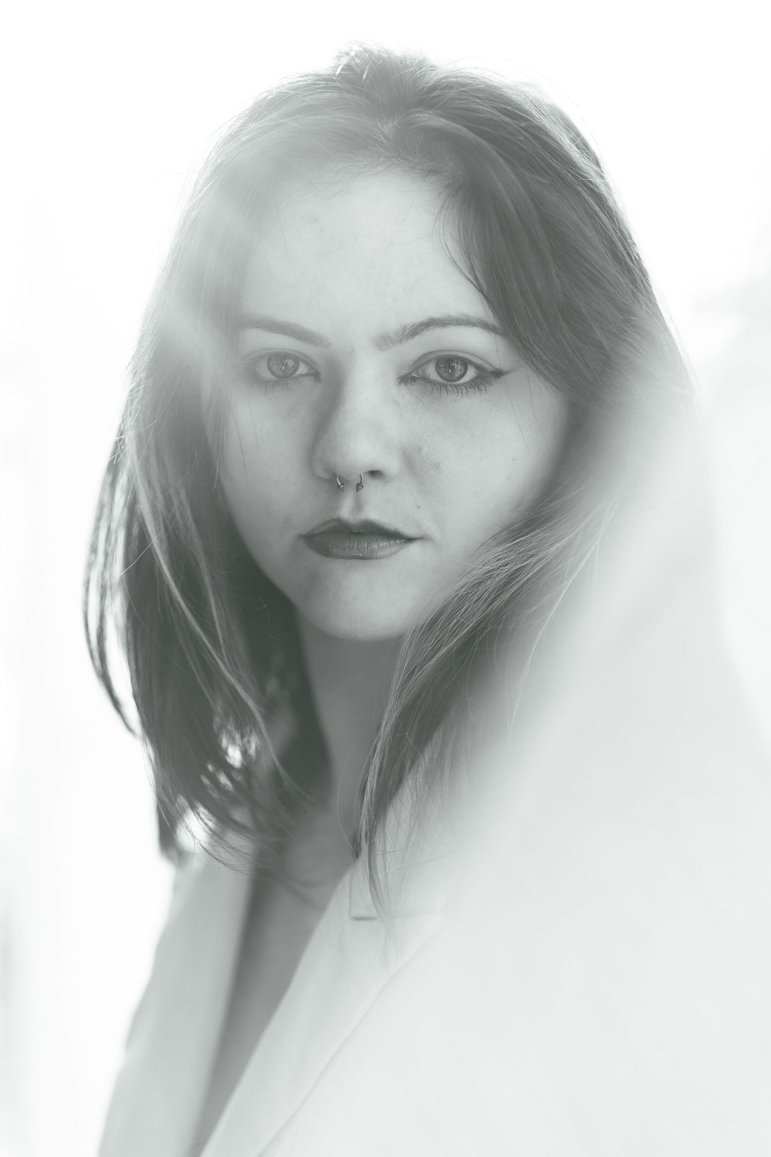 Black and white portrait photograph with dramatic high-key lighting and soft focus effects.