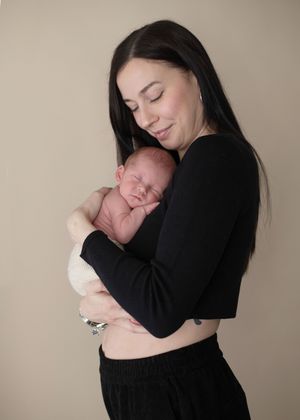 A pghoto showing a parent cradling and embracing a sleeping newborn baby.