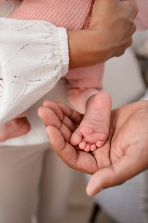 Close-up shot of tiny baby feet being cradled in adult hands.