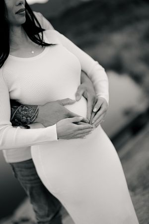 Black and white photo series showing a pregnant woman's growing belly in five progressive stages during pregnancy.