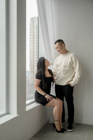 A couple poses intimately in three artistic black and white photographs by a bright window in a minimalist room.