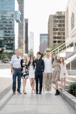 Group of friends and family standing together on urban concrete steps with modern buildings in background.