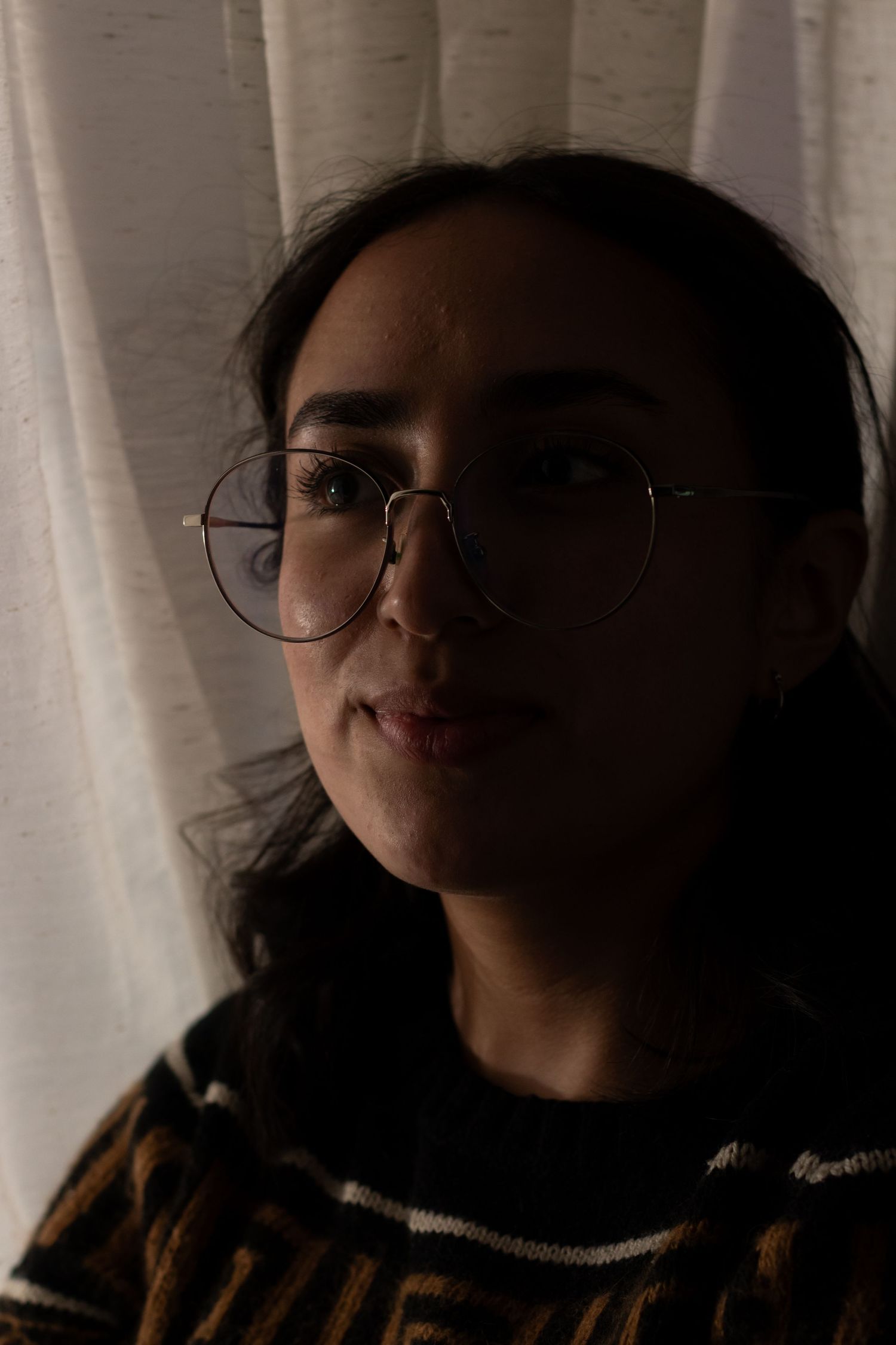 Silhouette against white curtain background in moody lighting.