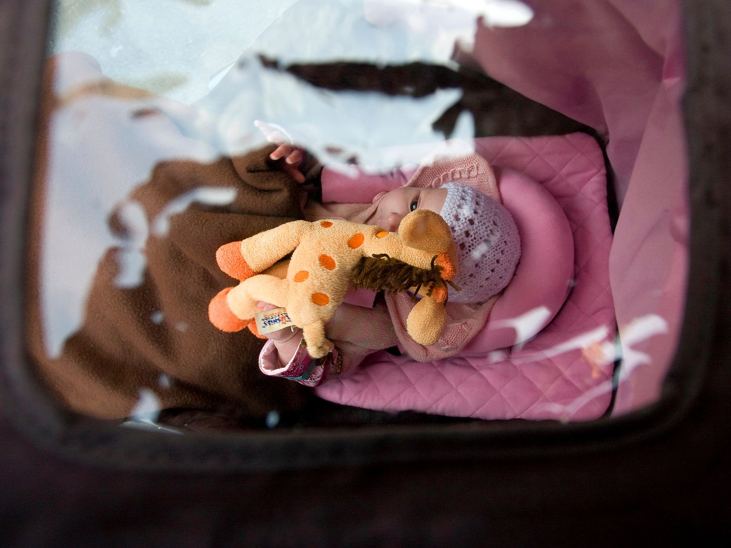 A gloved hand holds small toys or figurines in warm lighting.