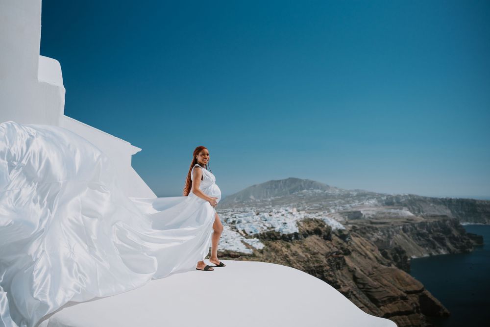 Dramatic bridal photo on white Santorini rooftop with sea views.
