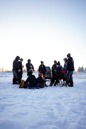 A group of people gathered on a snowy field during winter activities.