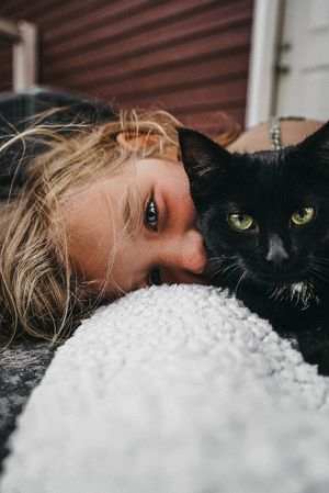 Close-up of a black cat and white textured surface in intimate portrait style.