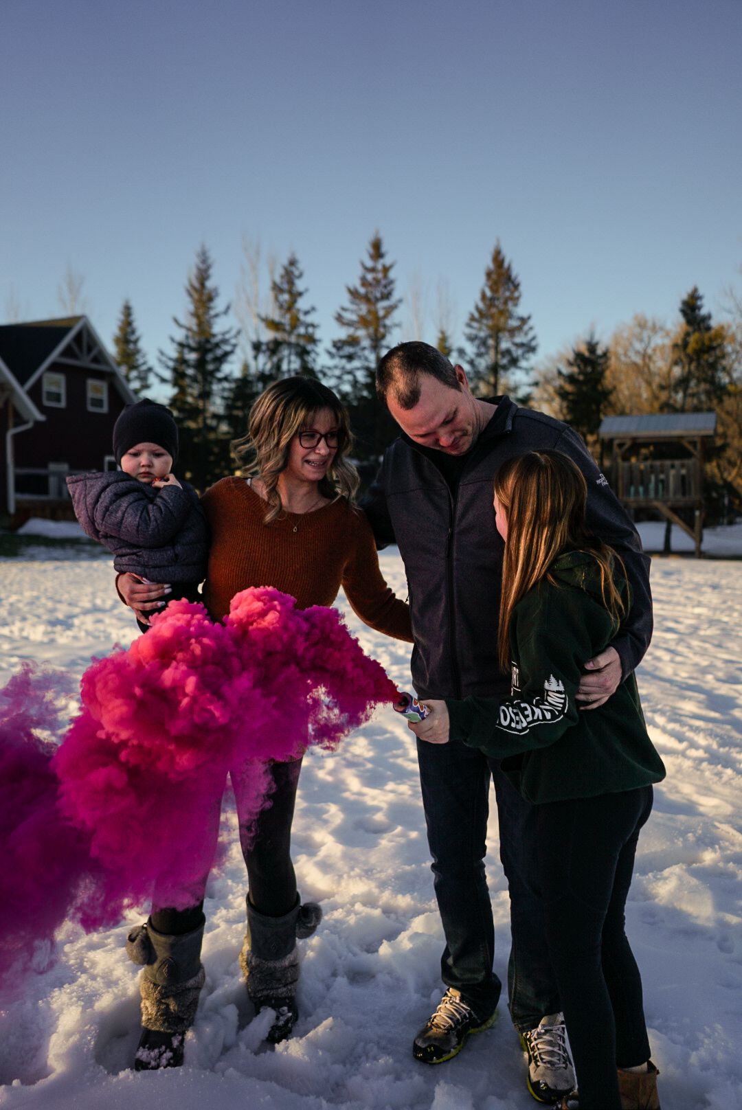 Friends creating colorful pink smoke effects while playing in deep snow.