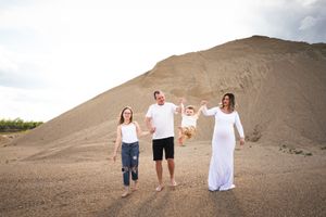 A group poses playfully on a desert hill during a casual outdoor photoshoot.