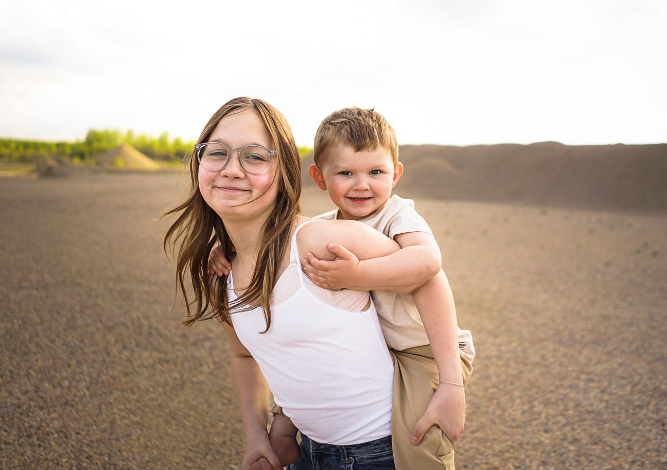 A heartwarming moment captured between two people outdoors on sandy terrain.