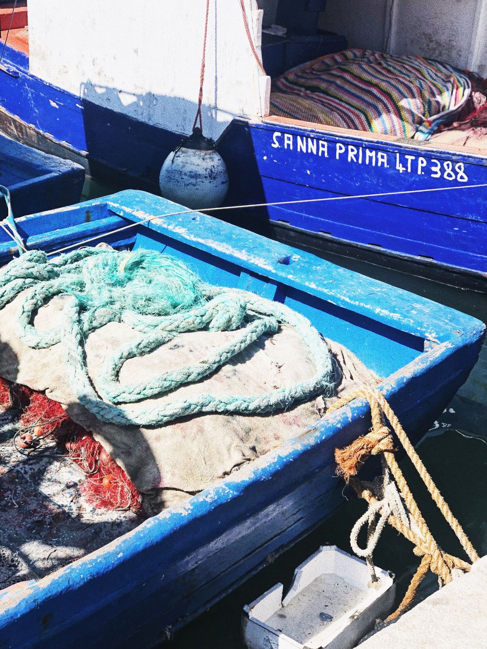 Fresh seafood and fish displayed in blue crates at market stall.