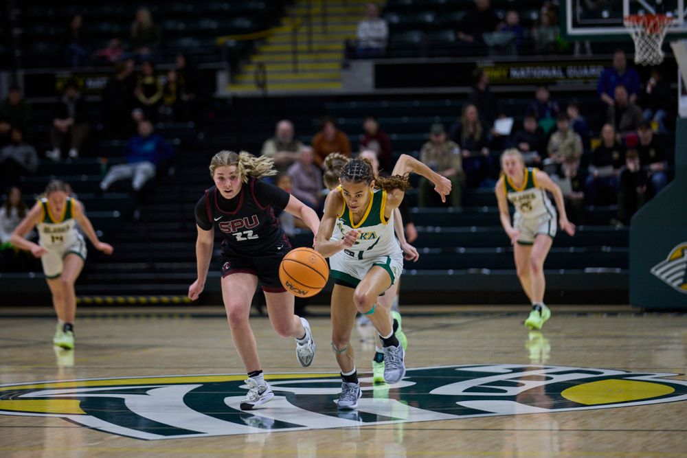 Basketball players battle for possession during intense game action.