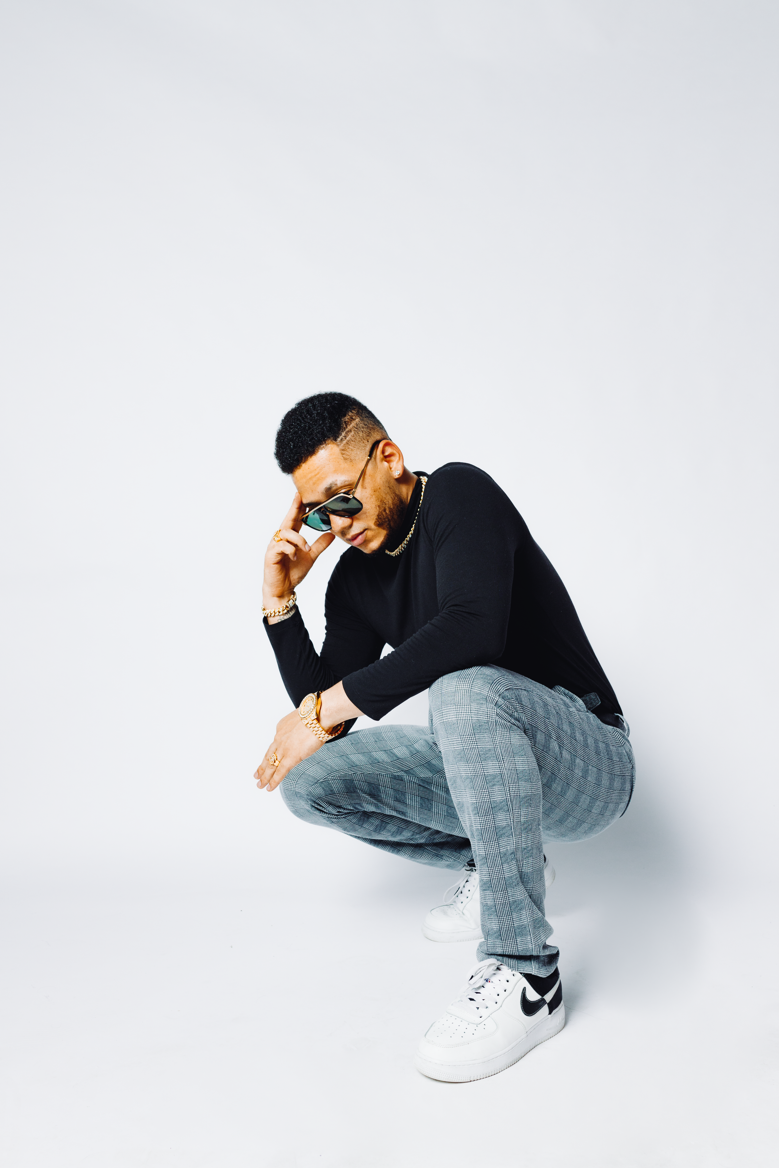 Stylish casual portrait against white background with modern sneakers and denim.