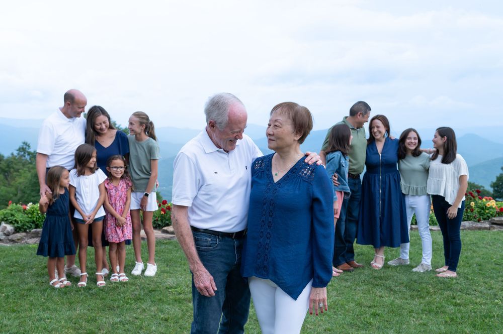 Group standing together on a grassy hillside during a summer gathering.