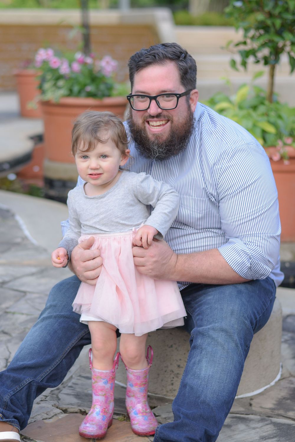 Sweet moment shared on garden stone steps with pink boots and striped shirt.