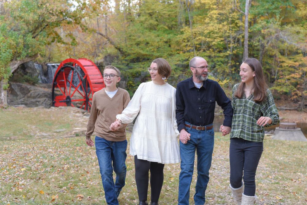 Group walking together through autumn trees on nature trail.