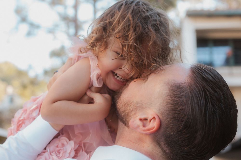 Joyful moment between parent and laughing toddler against blurred background.
