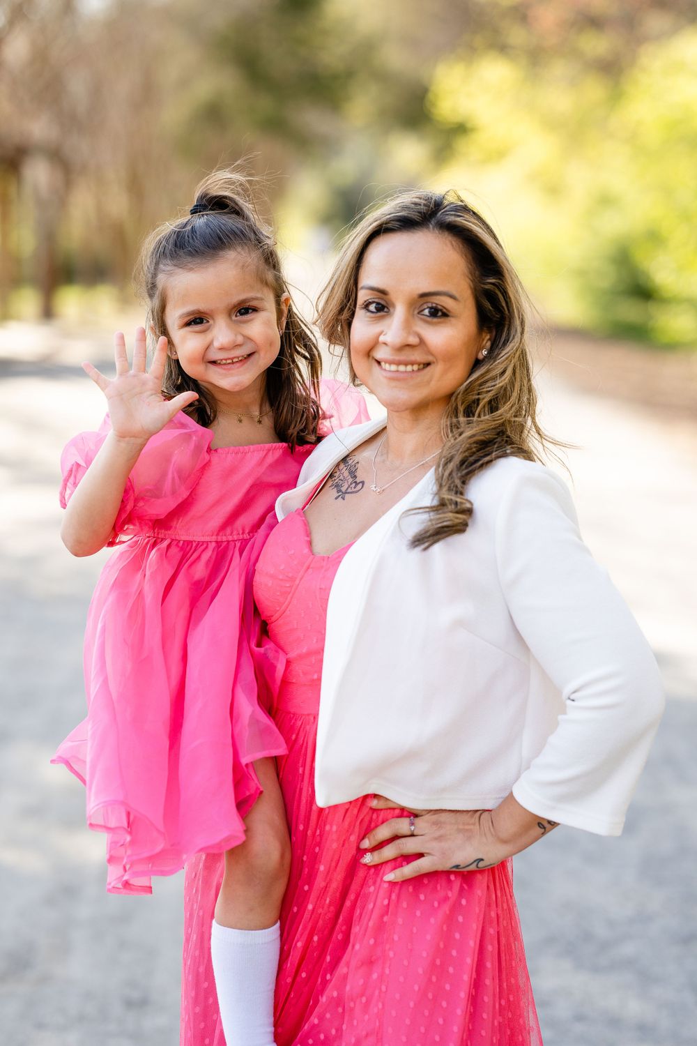 A springtime portrait featuring pink and white coordinated outfits on a tree-lined path.