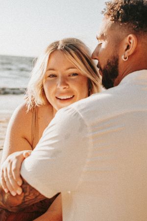 Close-up shot of a couple sharing an intimate moment at the beach.