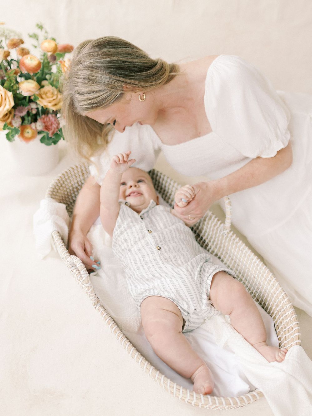Indoor Motherhood photo session with a backdrop and floral arrangements. Intimate motherhood session in Chico, Ca.