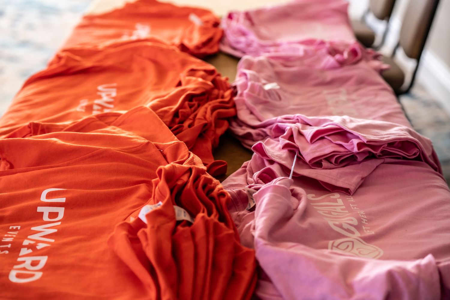 A collection of pink and orange fabric swatches arranged in a row showing different shades and textures.