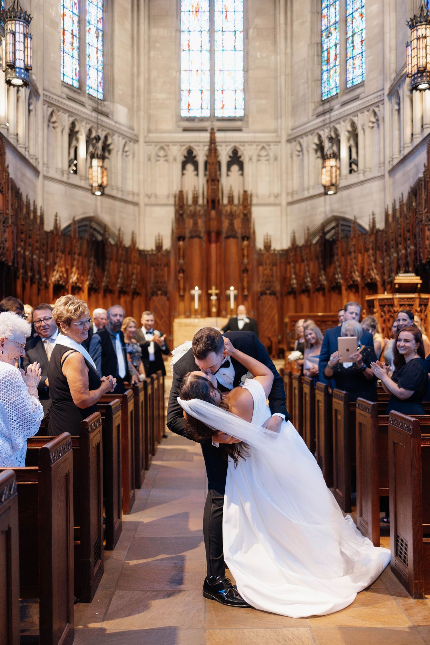 Bride and groom sharing a dip kiss during church wedding ceremony at Heinz Chapel, Pittsburgh, Pennsylvania