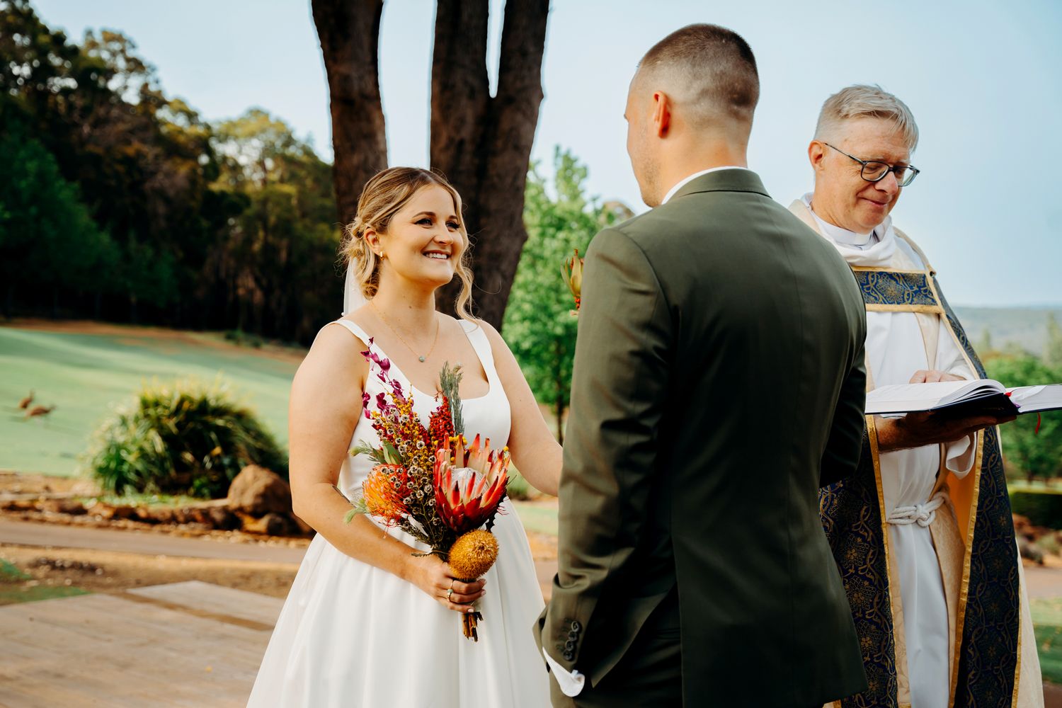 A wedding ceremony unfolds on a scenic outdoor terrace.
