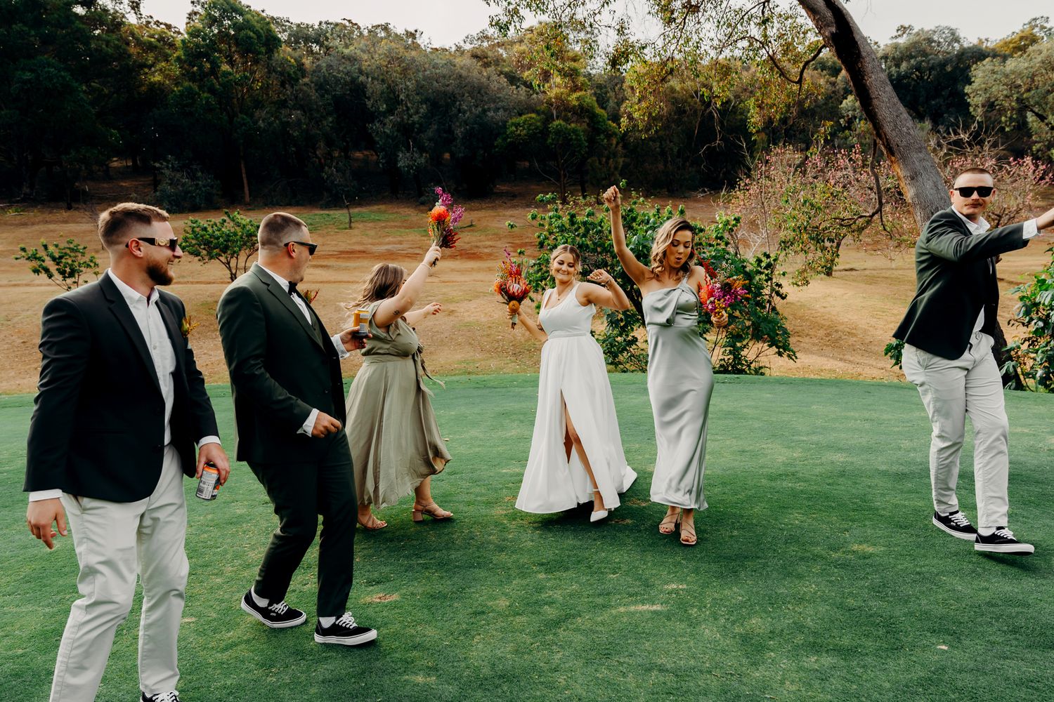 Candid moment of wedding party having fun on a golf course.