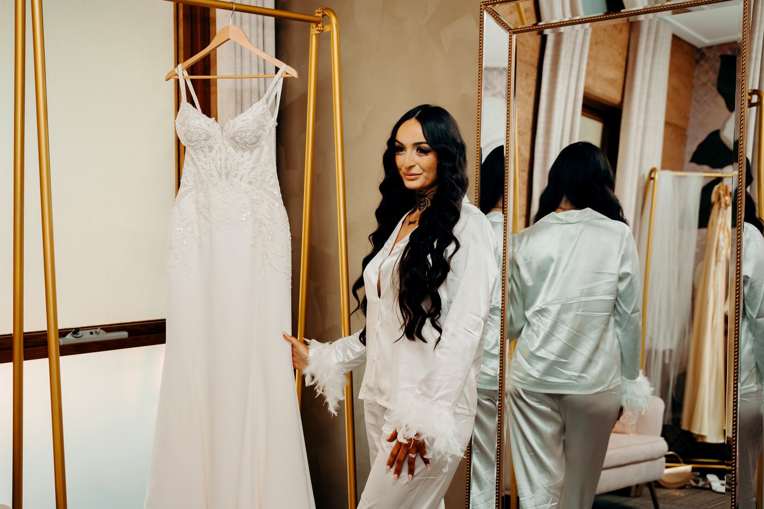 Beautiful white wedding dresses displayed in a bridal boutique with elegant lighting and mirrors.