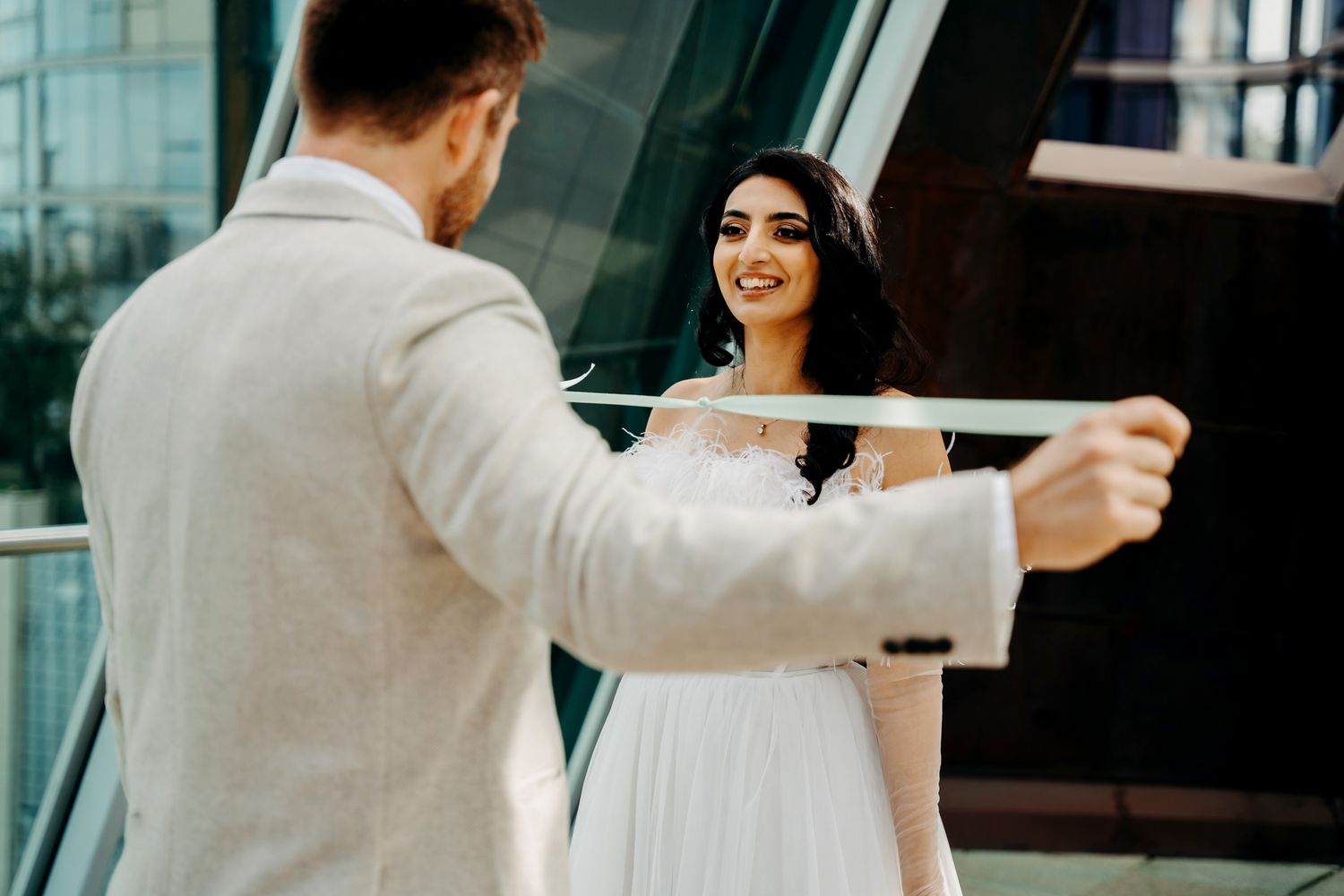 Joyful moment captured during first look on modern building terrace.