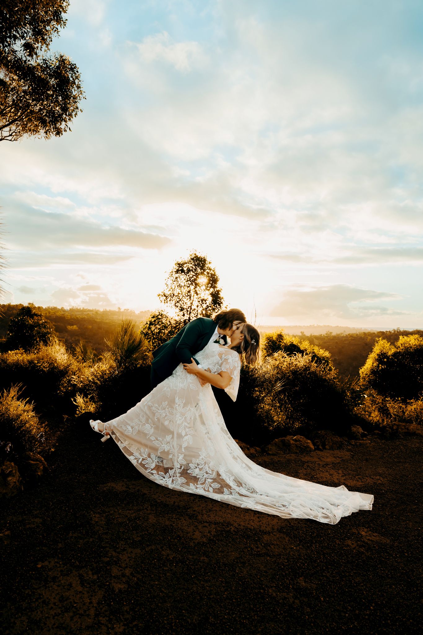 A romantic sunset wedding photo series showing a flowing white lace dress billowing in the golden light against nature.
